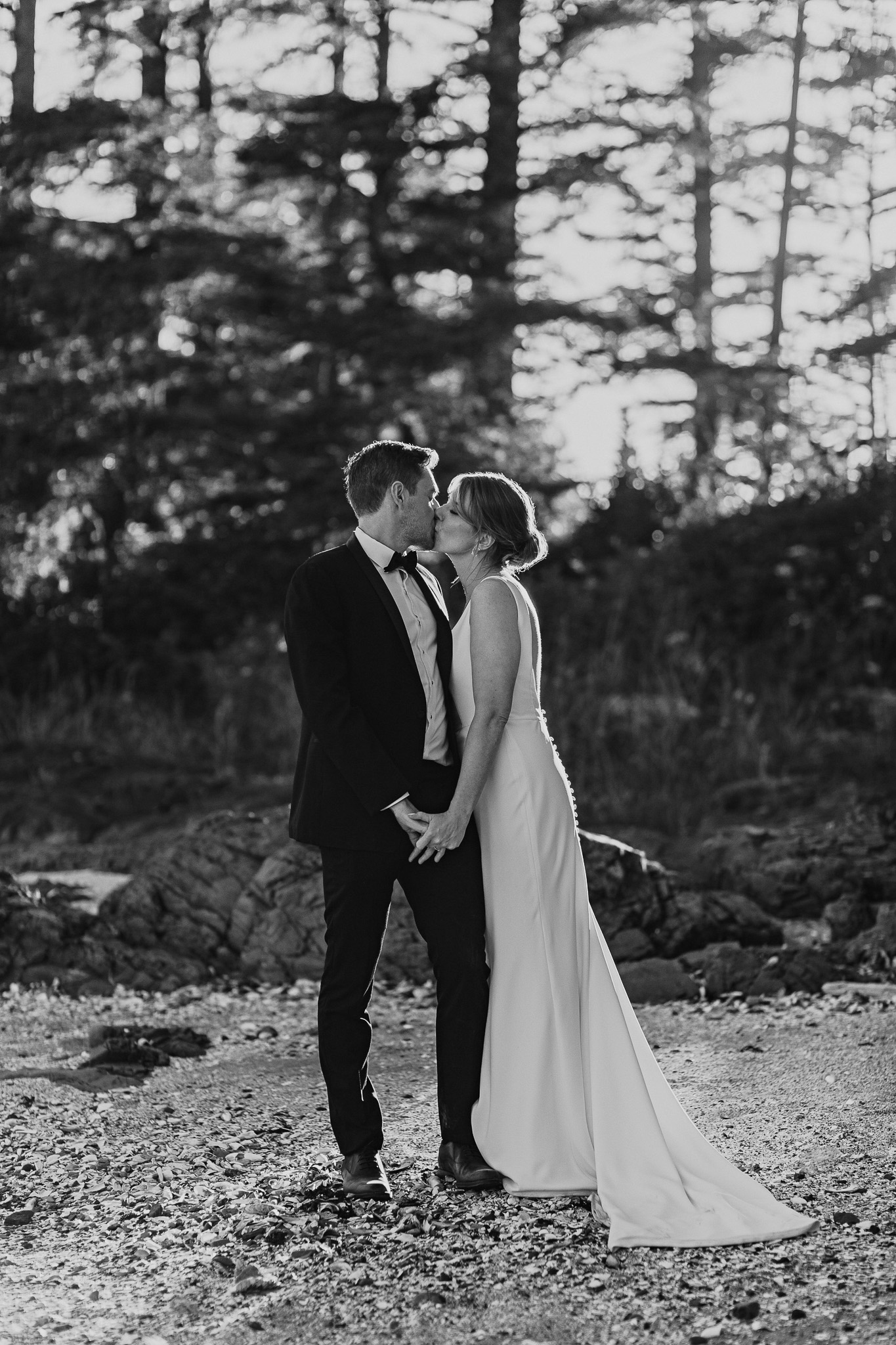 Black and White wedding protrait of a couple kissing at sunset on a private beach